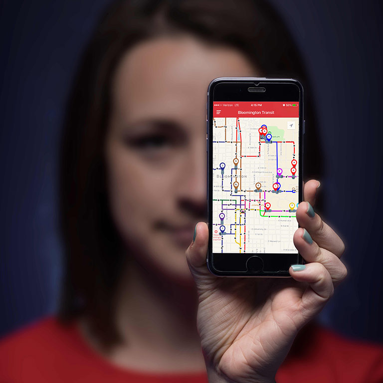 A woman holds a mobile phone displaying the DoubleMap app. 